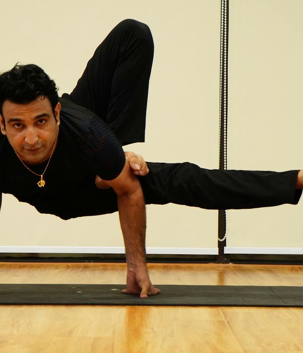 Man practicing balance and strength exercises in dark gym
